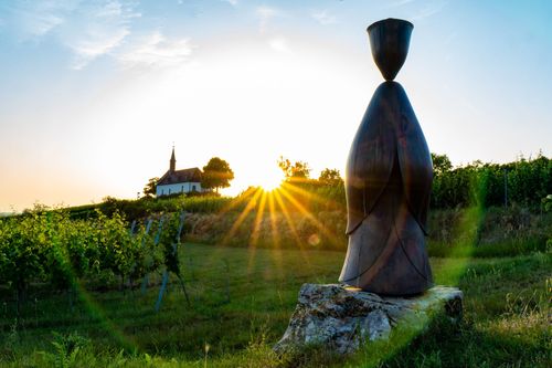Kirche Sankt Michael im Sonnenuntergang vom Skulpturenweg bei Abenheim